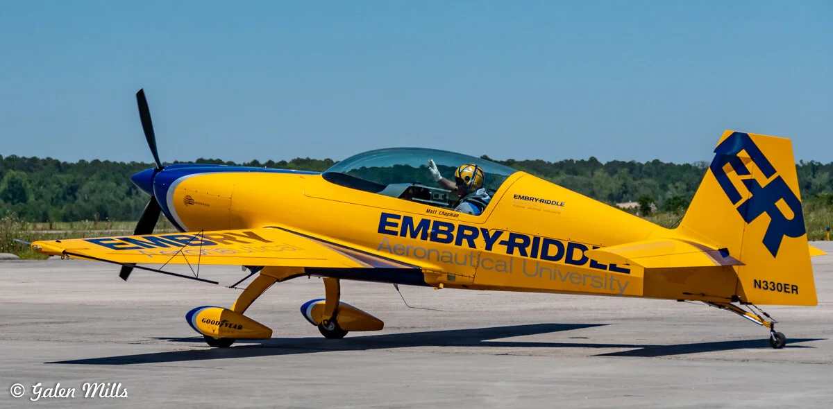 Yellow and blue Embry-Riddle Aeronautical University stunt plane on a runway