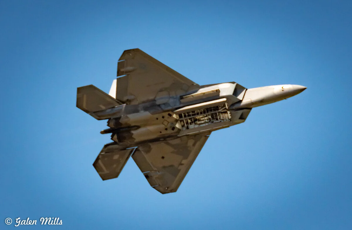 Military jet flying in clear blue sky