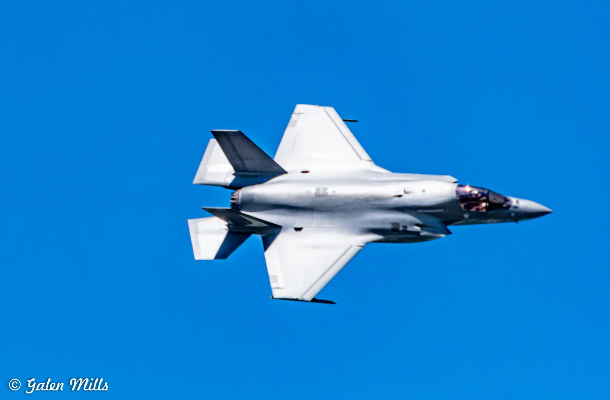 Fighter jet flying against a clear blue sky