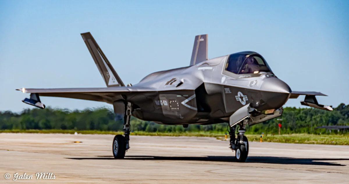 Lockheed Martin F-35 Lightning II military stealth fighter jet on runway with clear sky in background.