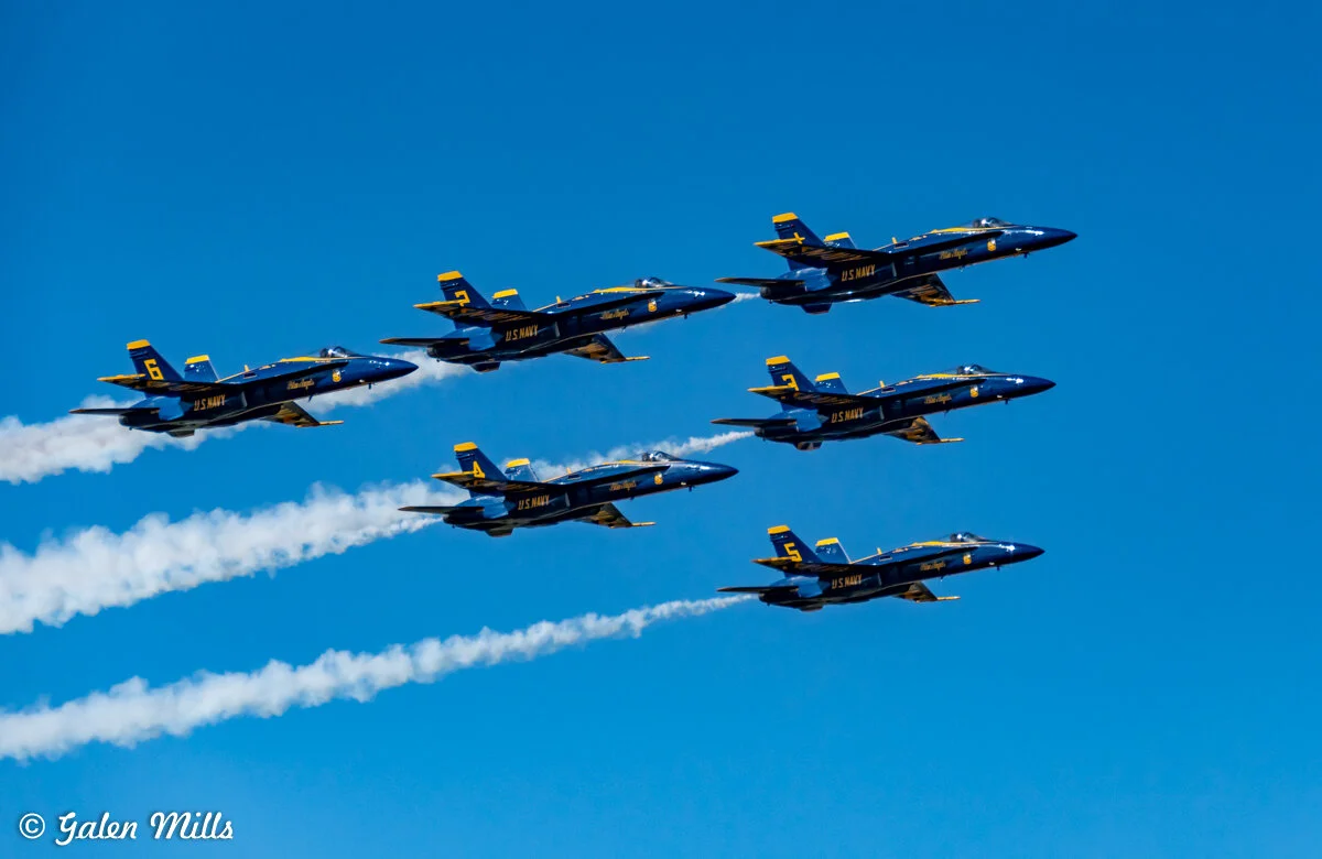 Blue Angels flying in formation against blue sky