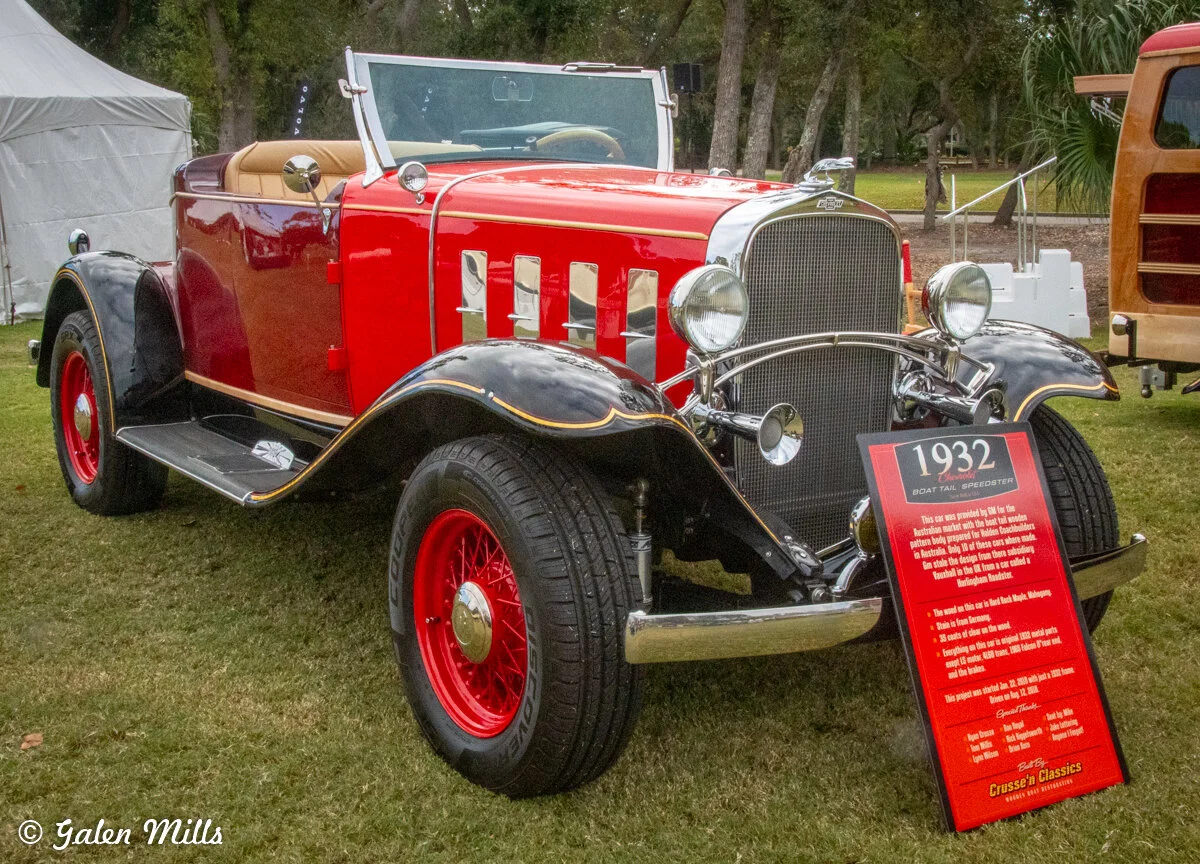 1932 classic red and black car on display with informational sign.