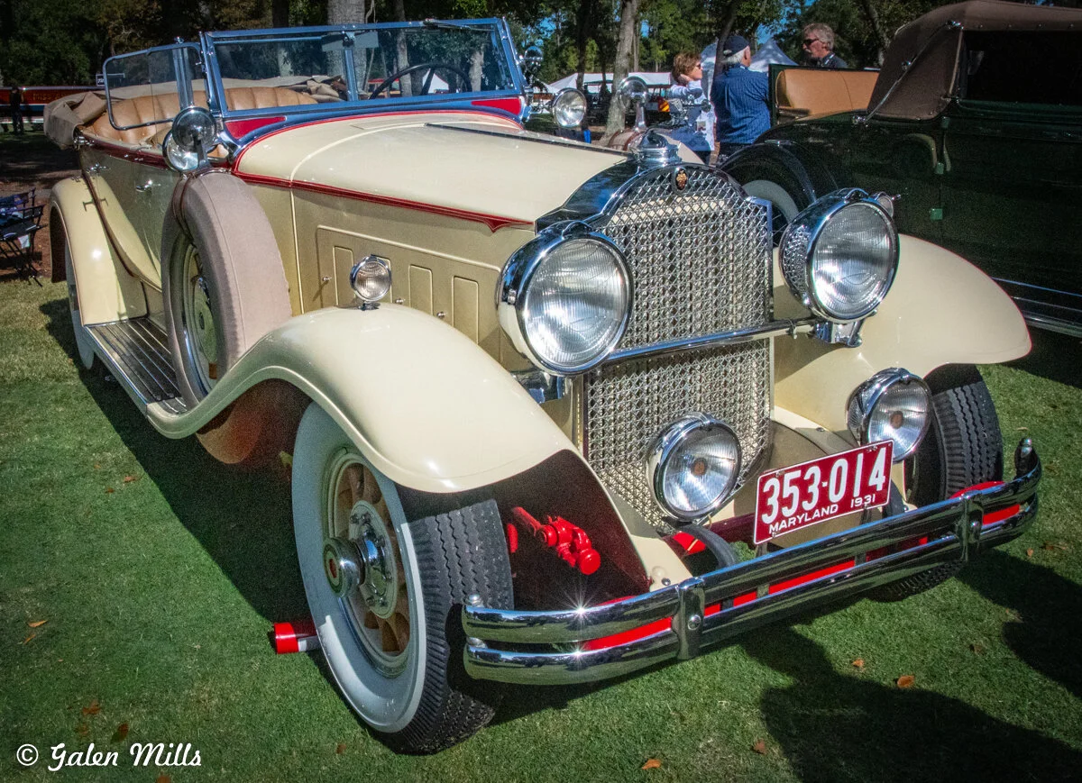 Vintage 1931 classic car with Maryland license plate displayed at an outdoor car show, surrounded by people and trees.