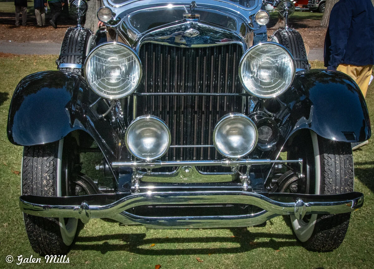 Front view of a vintage car with chrome grille and round headlights