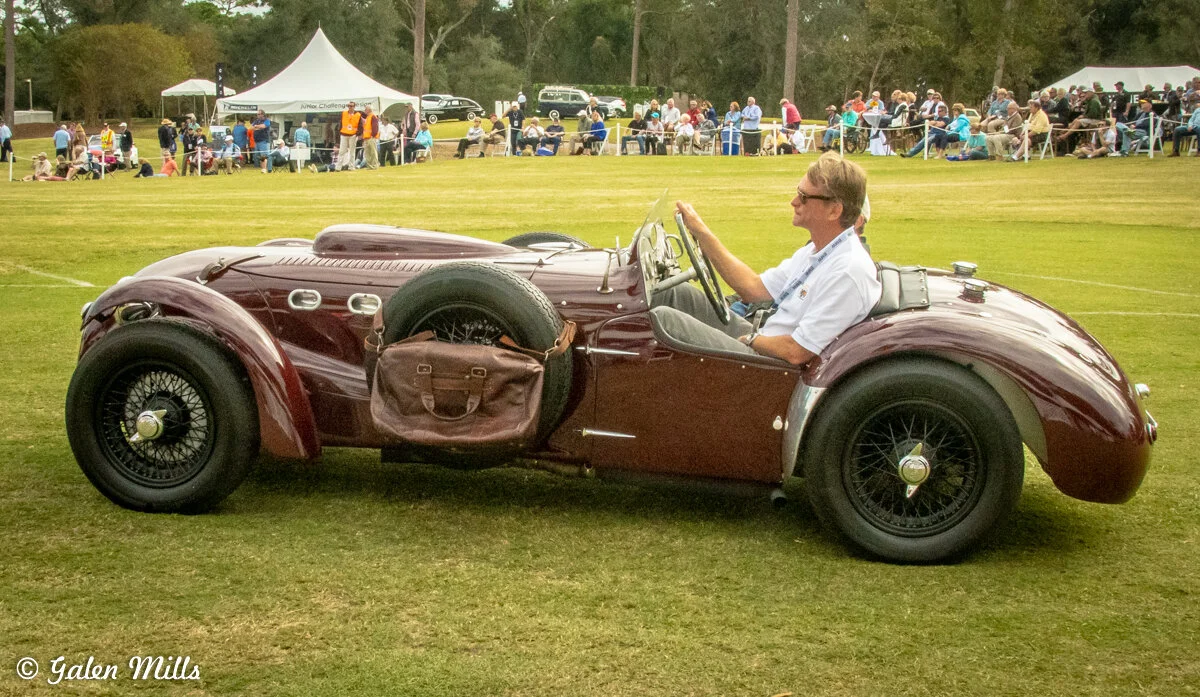 Classic vintage car with driver at an outdoor event