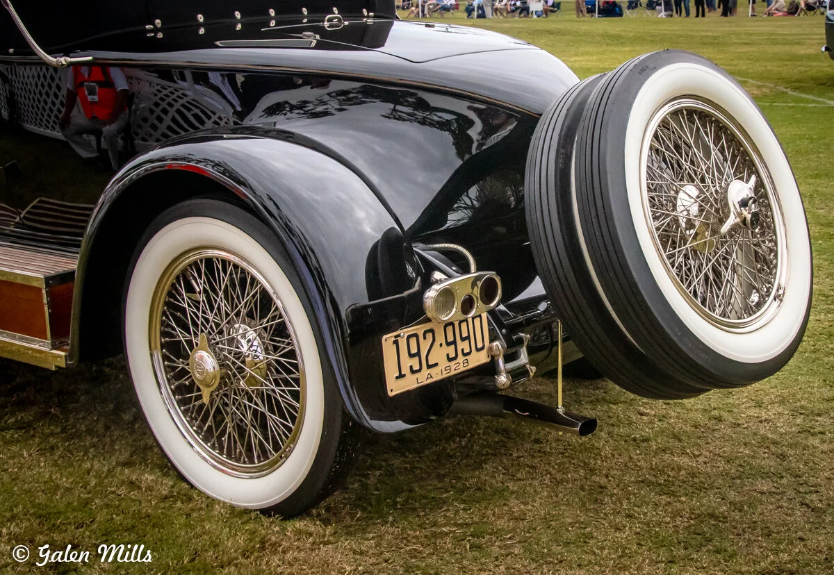 Vintage car rear view with spare tire, wire wheels, and 1928 license plate