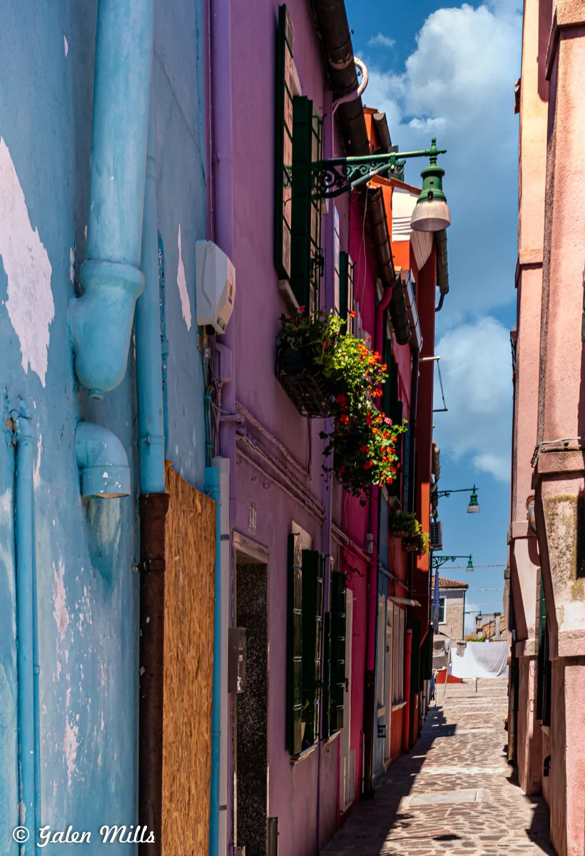 Narrow alley with colorful buildings, blue sky