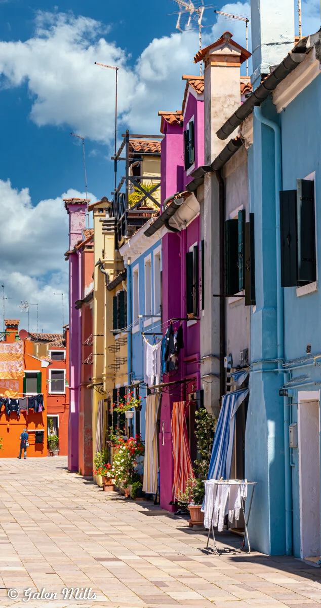Colorful houses on a street with laundry hanging and potted plants