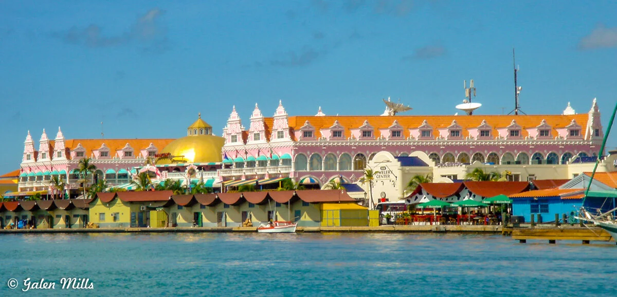 Colorful Dutch colonial-style building and waterfront shops in Oranjestad, Aruba.
