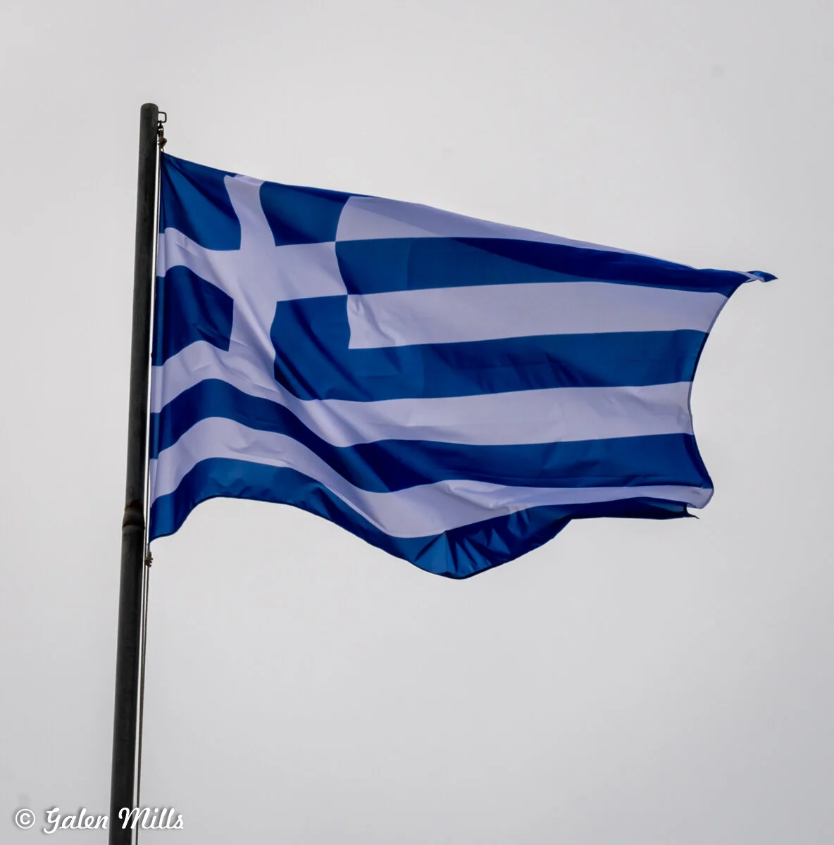 Greek flag waving against the sky.
