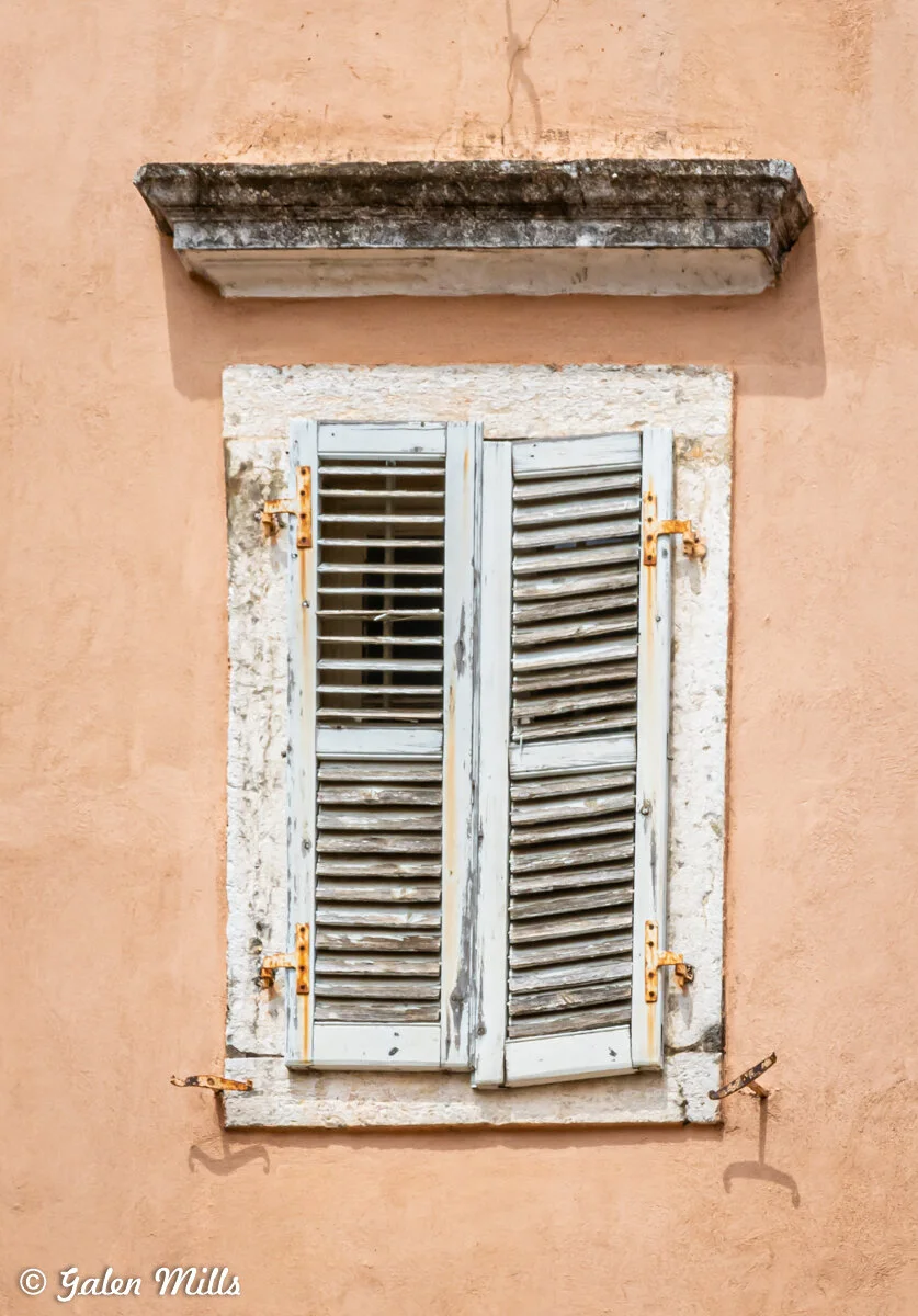 Rustic wooden shutters on a peach-colored wall