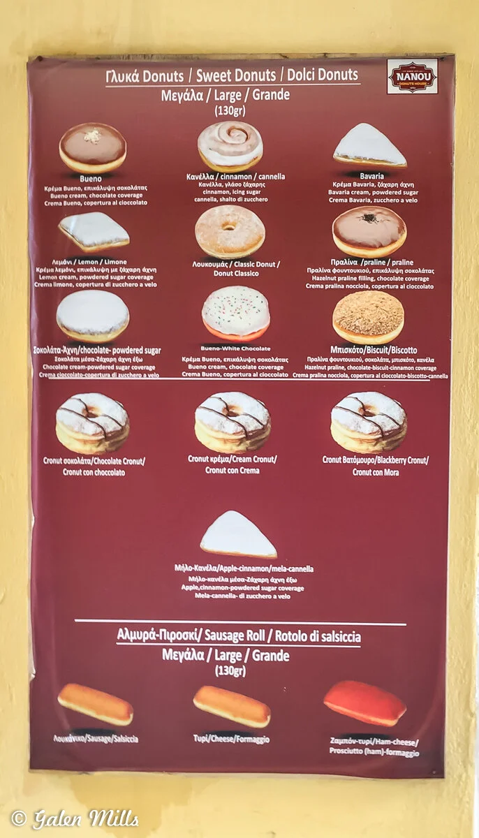Menu displaying different types of donuts and sausage rolls. Includes options like Bueno, Cinnamon, Bavaria, Lemon, Classic, Praline, Biscuit, various cronuts, and apple-cinnamon donuts. Sausage roll options include Sausage, Cheese, and Ham-cheese va