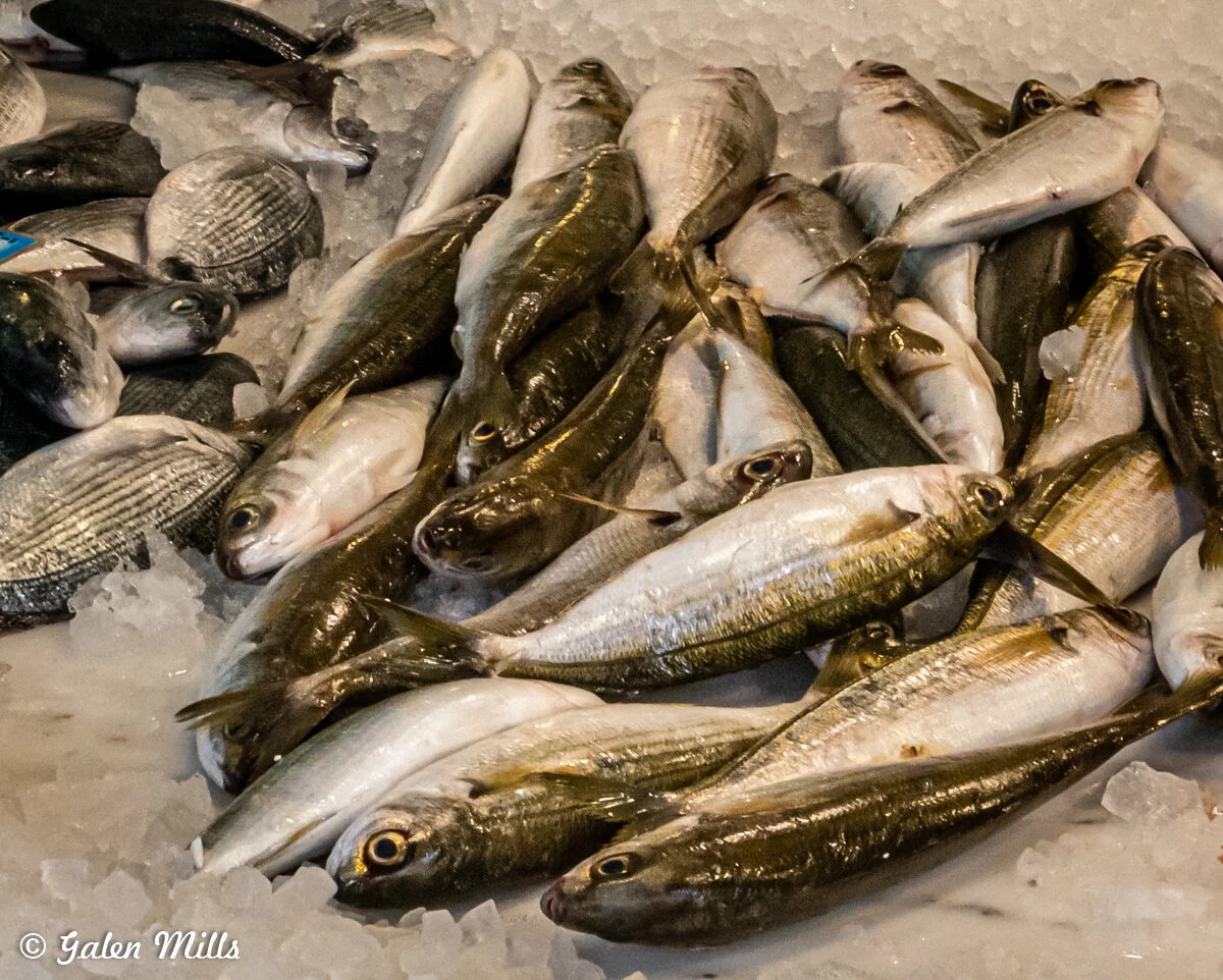 A pile of fresh fish on ice at a seafood market.