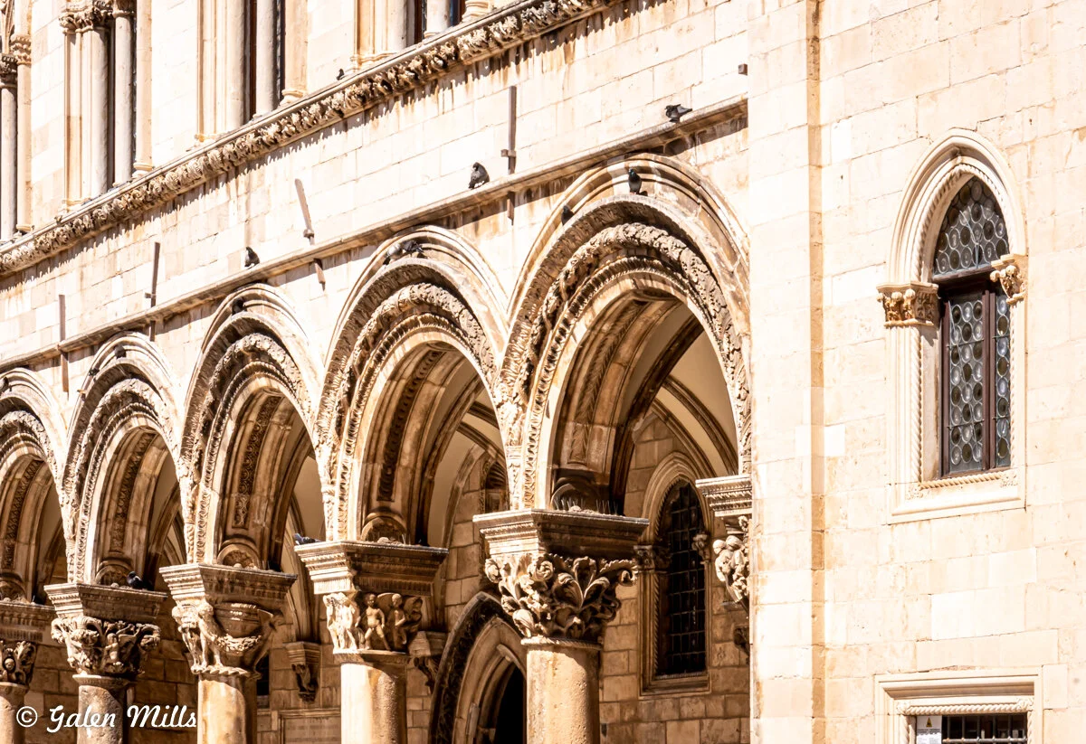 Historic building facade with ornate stone arches and columns
