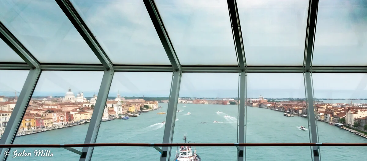 View of Grand Canal in Venice from a boat with glass windows, showcasing surrounding historic buildings and architecture.