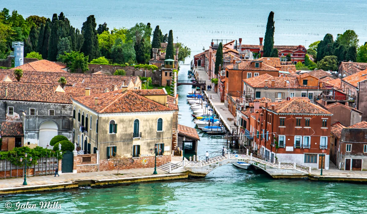 Aerial view of a canal in Venice with colorful buildings and boats.