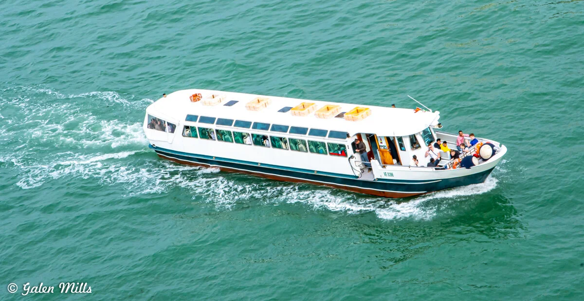 Passenger boat on green water with people on deck