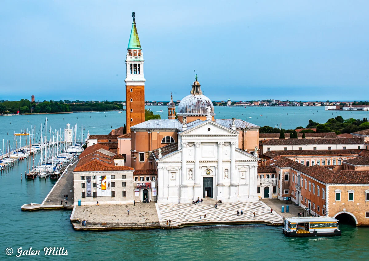 San Giorgio Maggiore in Venice, Italy, featuring a tower, dome, and waterfront with boats.