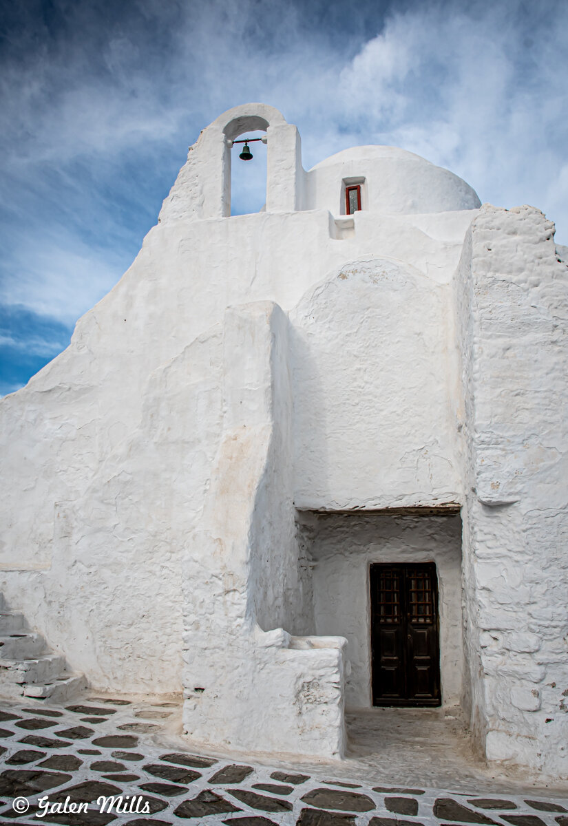 Whitewashed church with bell on a Greek island