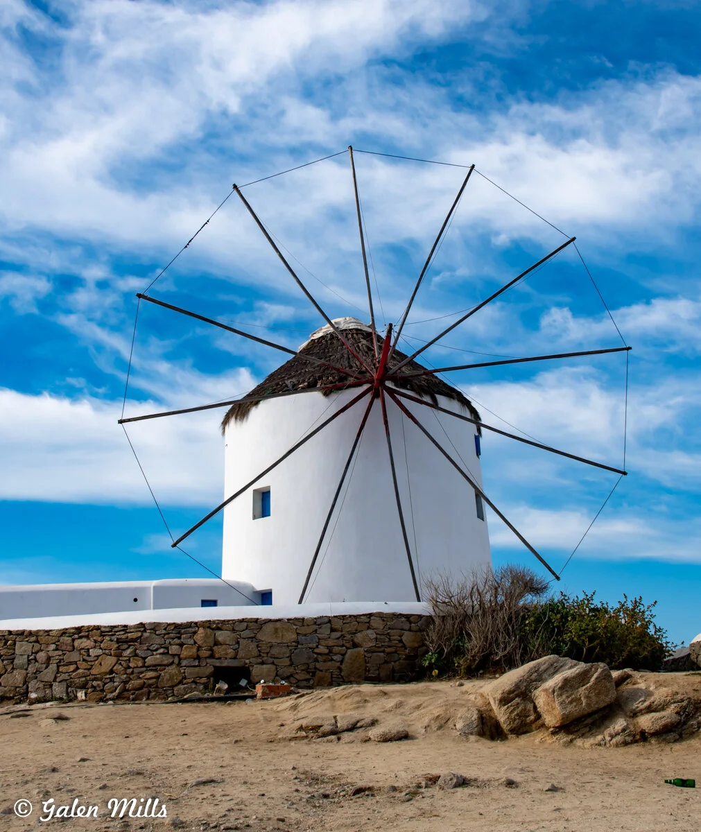 Traditional white windmill with blue sky in Mykonos, Greece.