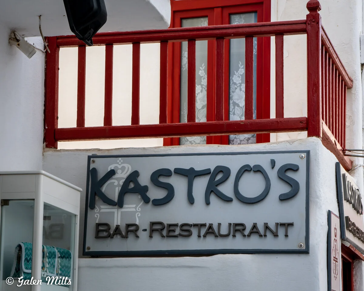 Sign for Kastro's Bar-Restaurant with red balcony and door.