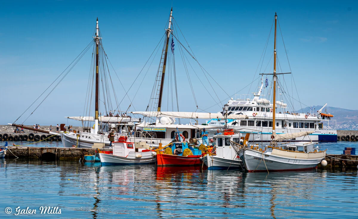 Boats and yachts docked in a harbor with clear blue sky