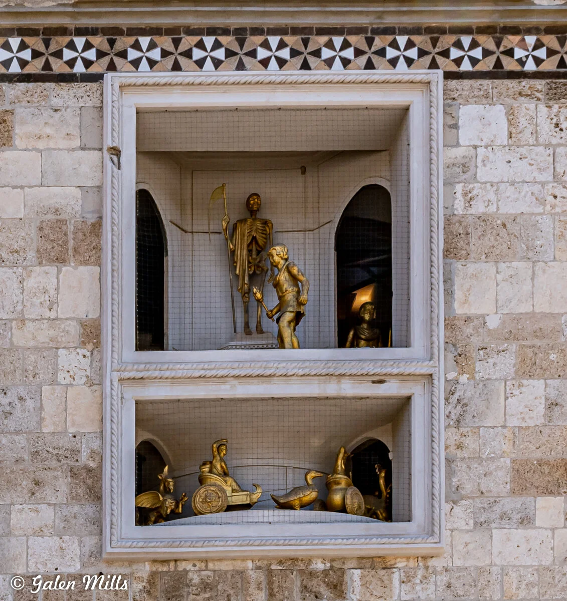 Golden mechanical figures in clock tower compartments