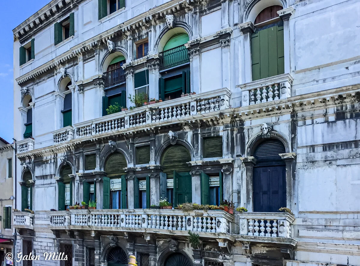 Historic building with ornate facade and green shutters in Venice, Italy