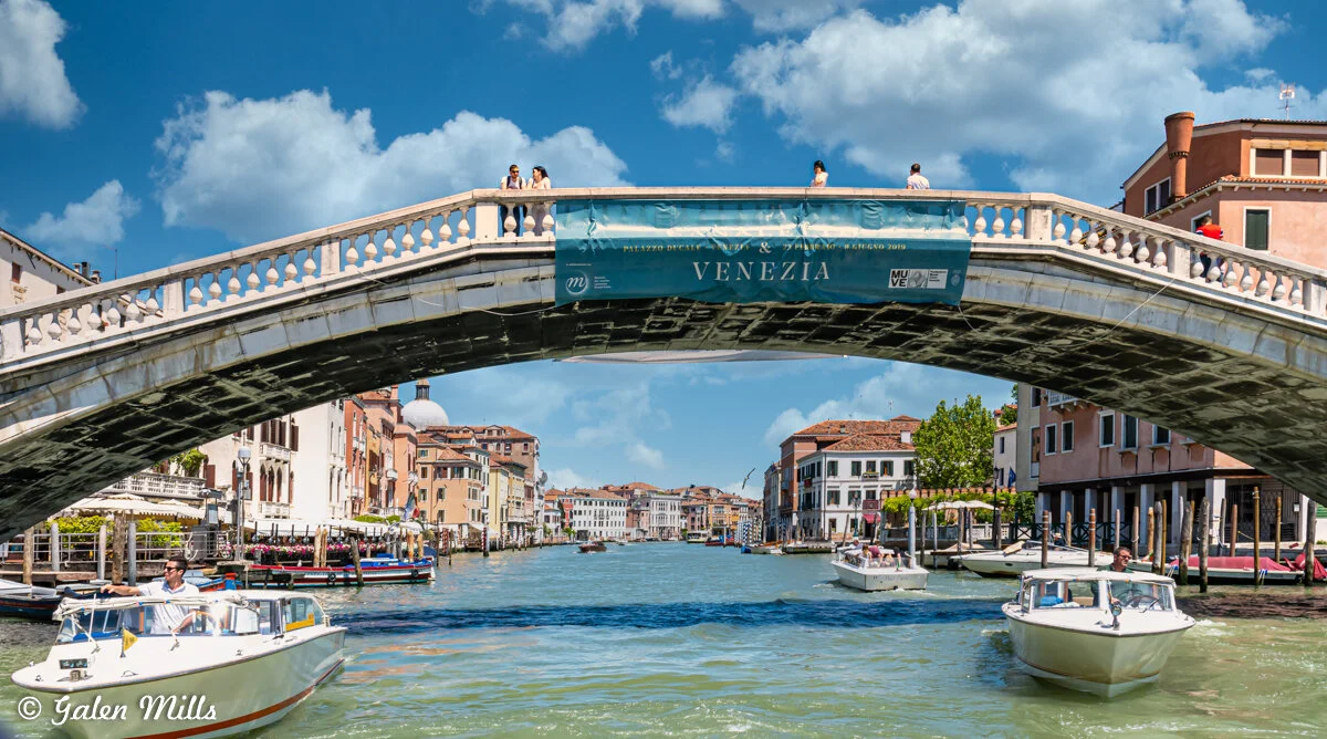 Scenic view of a Venice canal with a stone bridge and boats