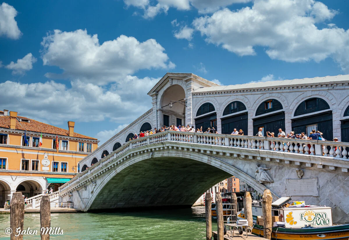 Rialto Bridge in Venice with tourists and gondola on canal