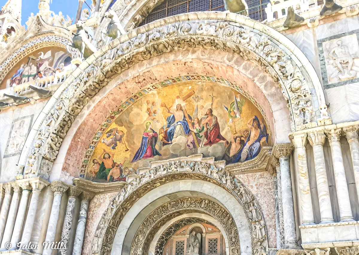 Exterior mosaic of St. Mark's Basilica featuring religious figures and intricate architectural details.