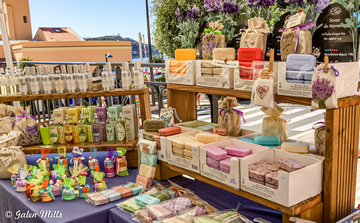 Colorful soaps and lotions displayed at an outdoor market stall.