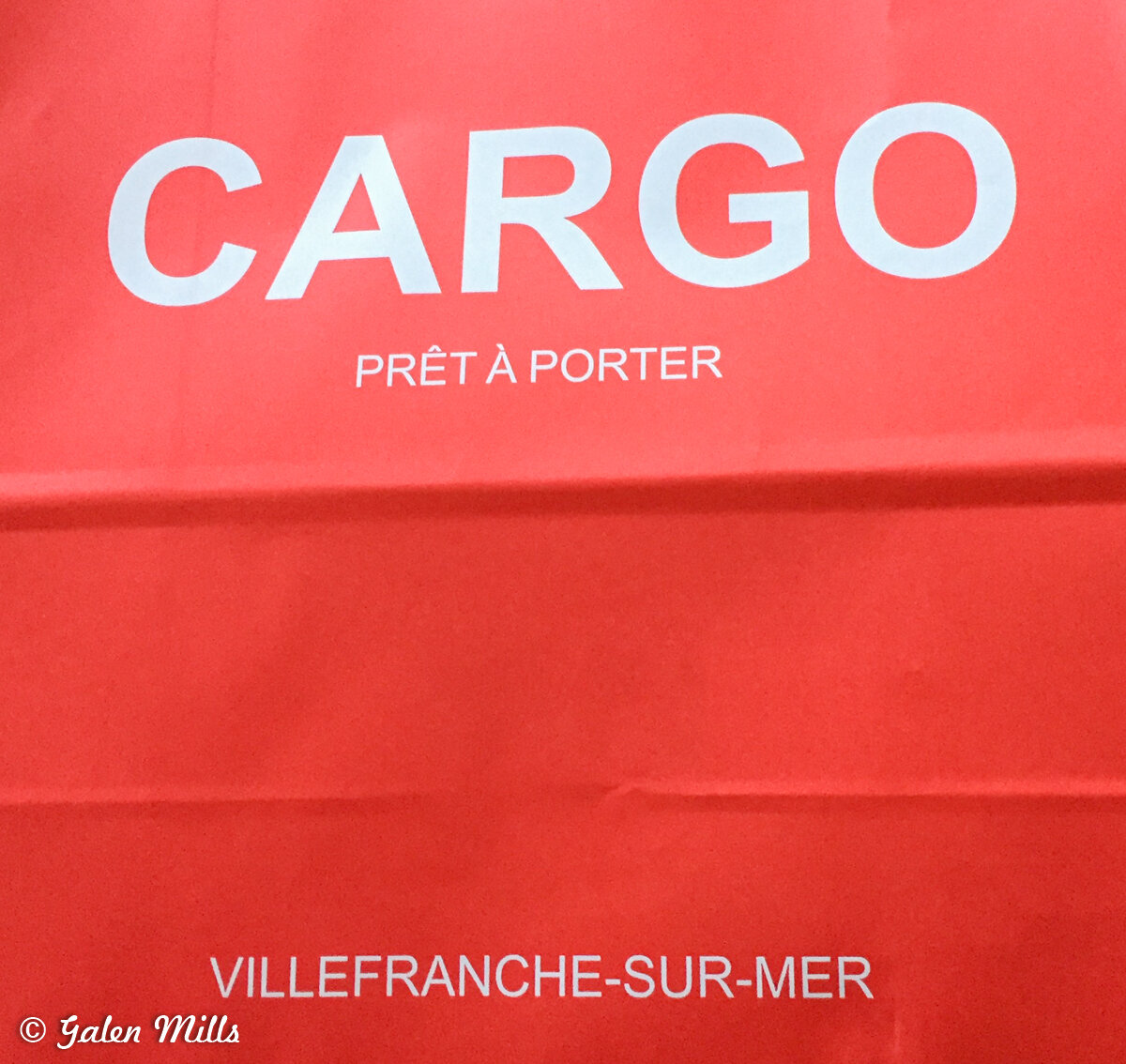 Red bag with 'CARGO Prêt à Porter Villefranche-sur-Mer' printed on it.