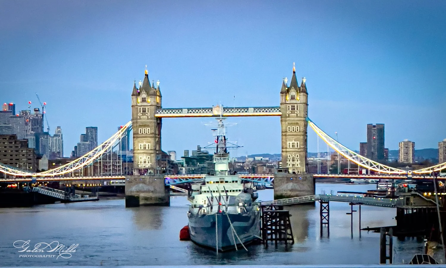 Tower Bridge in London with a ship on the River Thames at dusk