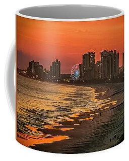 A mug featuring a city skyline at sunset with a ferris wheel and reflections on water.