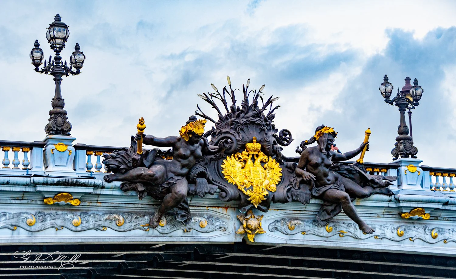 Ornate sculptures and lampposts on Paris's Pont Alexandre III bridge.