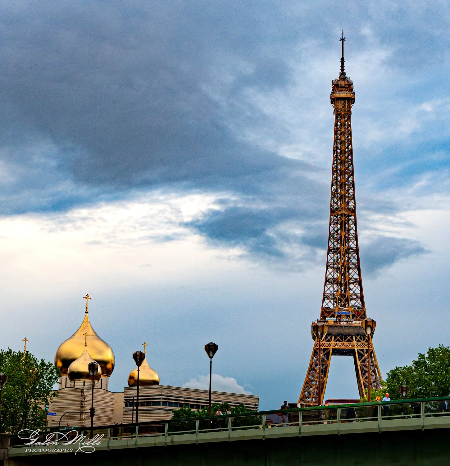 Eiffel Tower and Russian Orthodox Cathedral with golden domes in Paris, cloudy sky