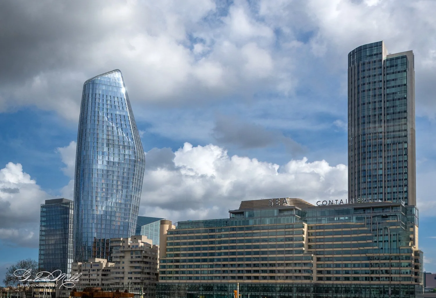 Modern skyscrapers in a cityscape with cloudy sky.