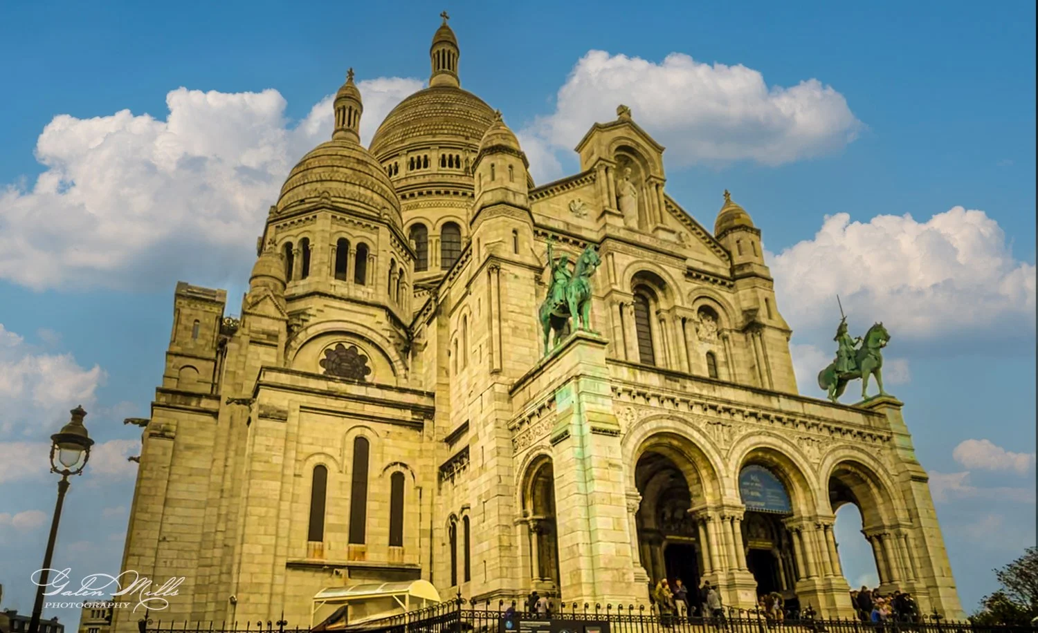 Sacré-Cœur Basilica in Paris with cloudy sky.