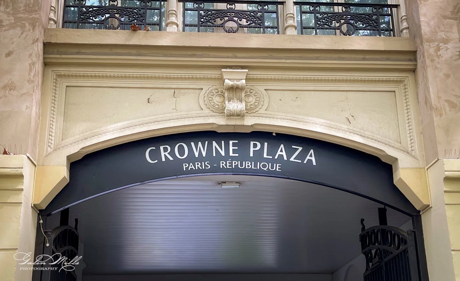 Crowne Plaza Paris République sign above an entrance with ornate architectural details.
