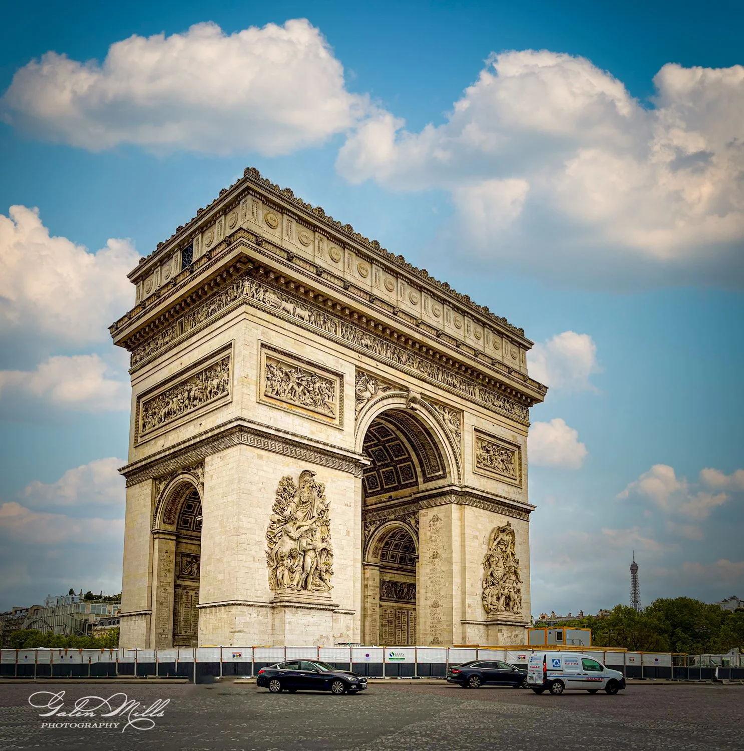 Arc de Triomphe with cloudy sky and cars on street