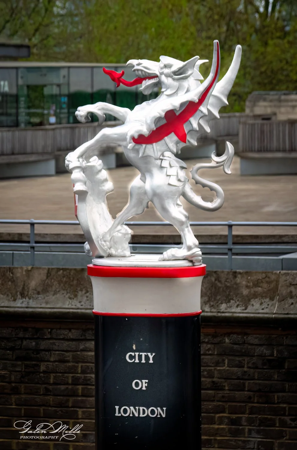 A silver dragon statue with red accents on a pedestal marked 'City of London'.