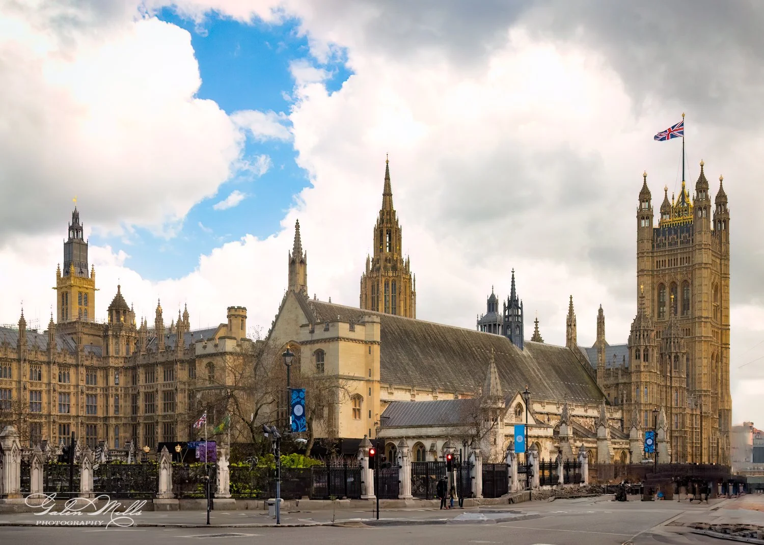Houses of Parliament in London on a cloudy day with the Union Jack flying.