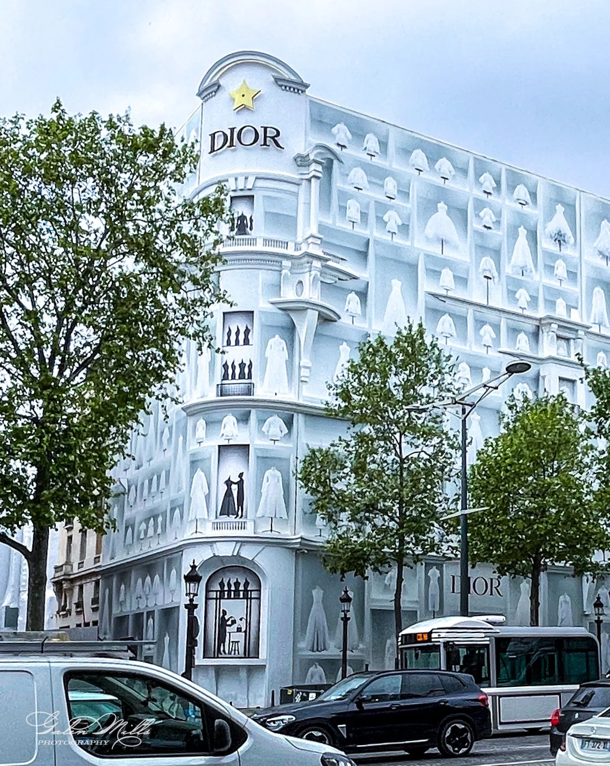 Dior building with fashion-themed facade and street view.