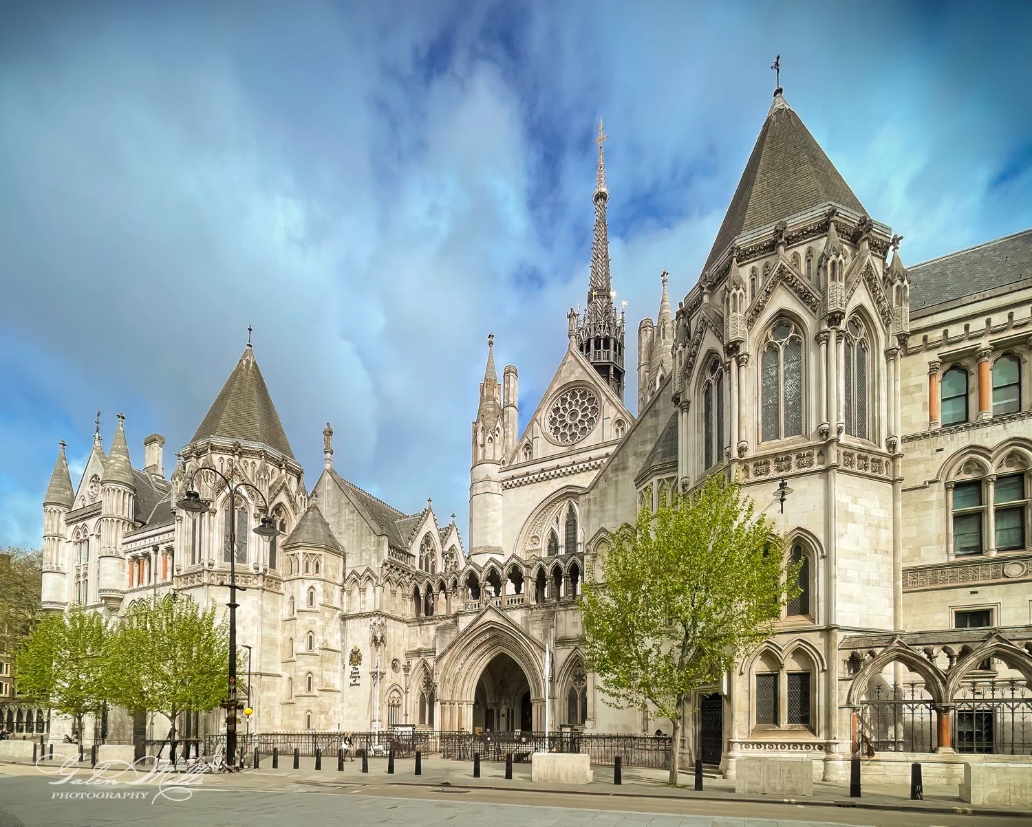 Royal Courts of Justice, London, gothic architecture, sunny day, blue sky, trees lining the street