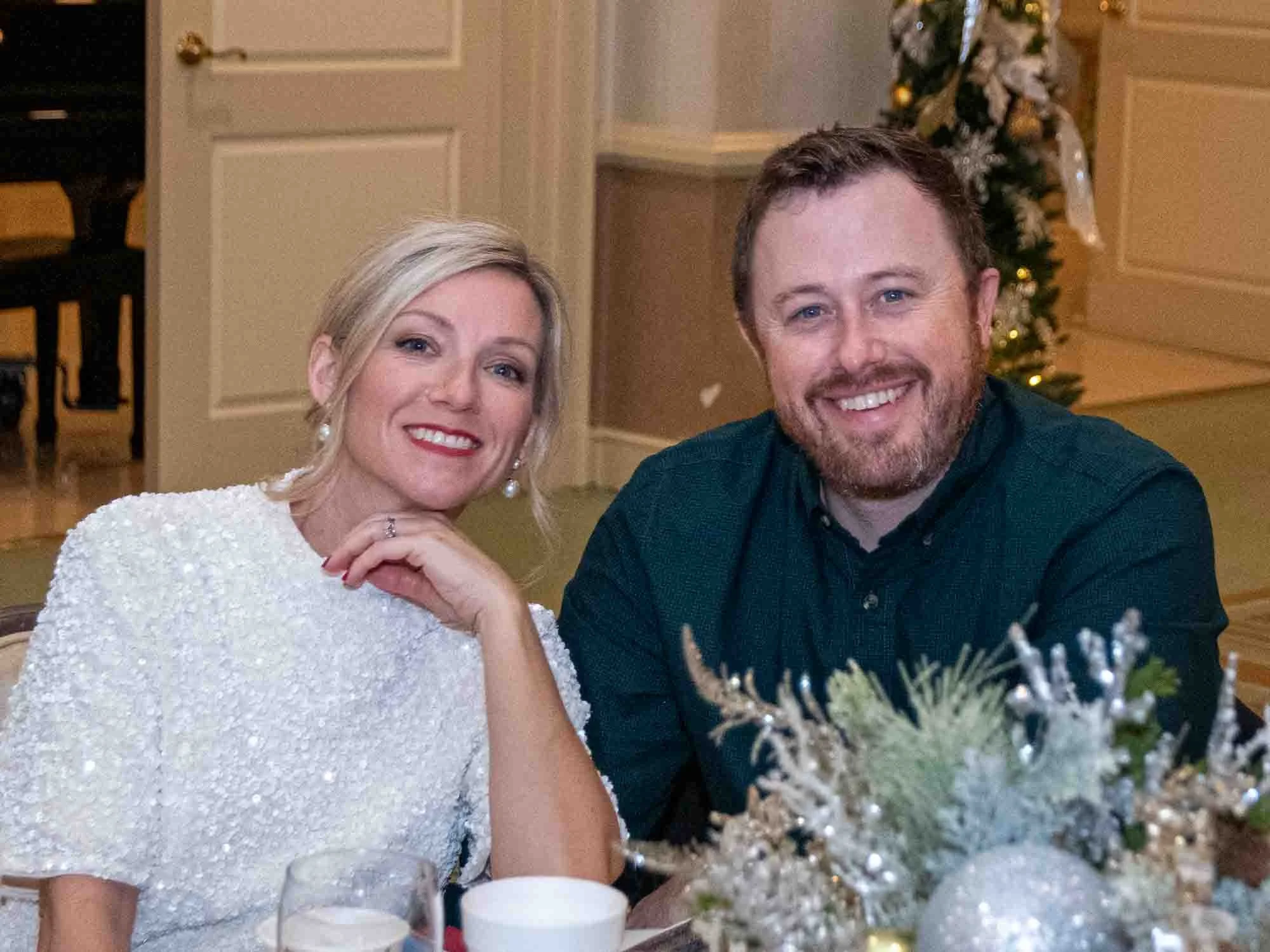 Smiling couple seated at a table with holiday decorations