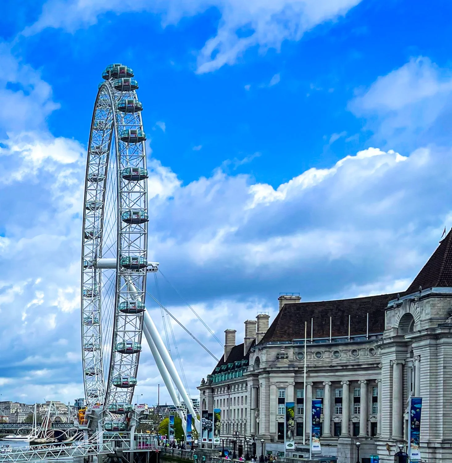 London Eye and County Hall against partly cloudy sky