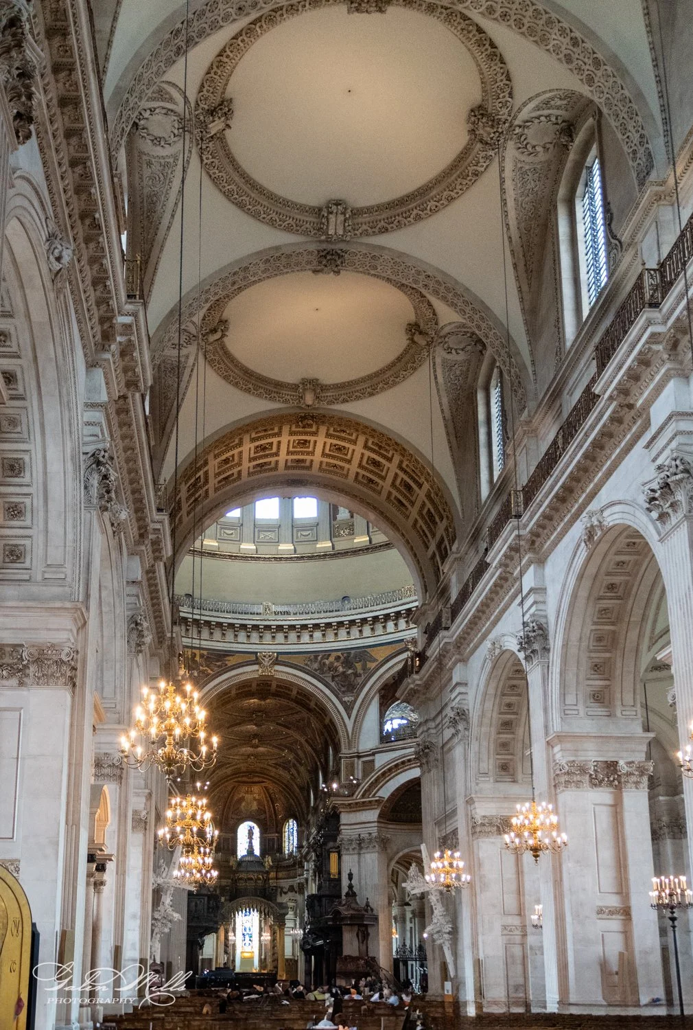 Interior of a grand cathedral with ornate arches, chandeliers, and intricate architectural details.