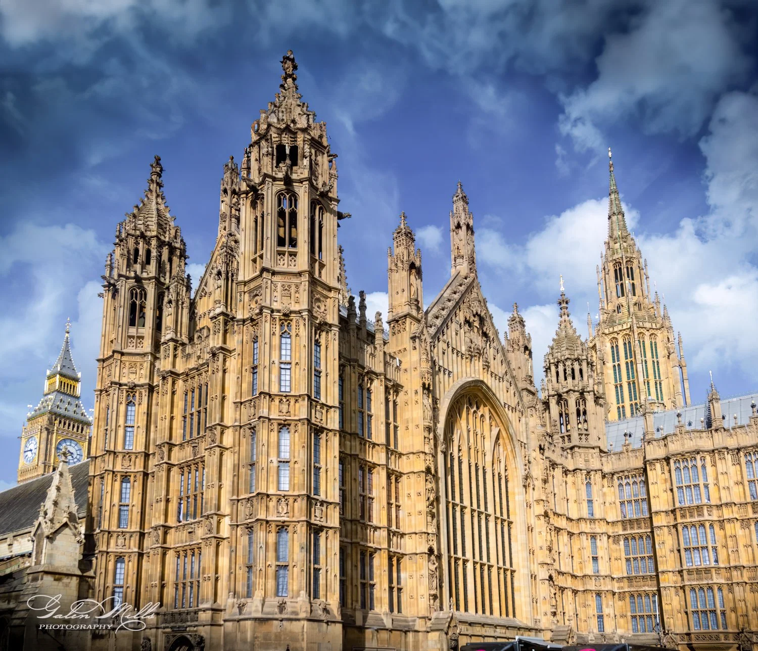 The Palace of Westminster, featuring Big Ben, with Gothic architecture, under a blue, cloudy sky.