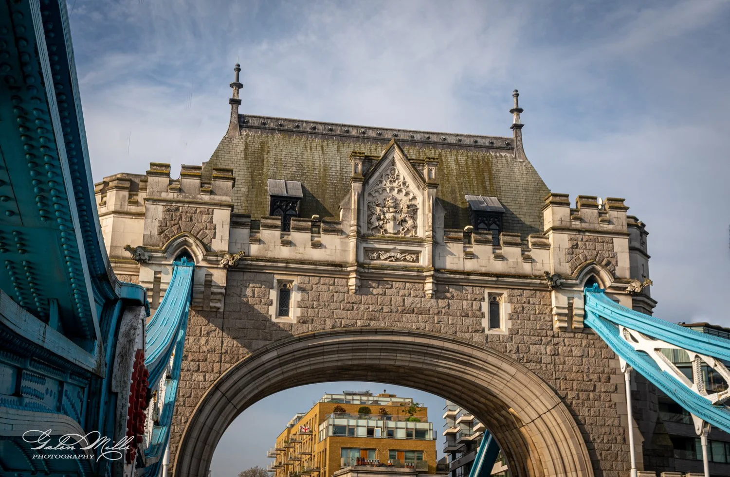 Close-up of Tower Bridge in London, focusing on the stonework and architectural details with blue suspension elements.